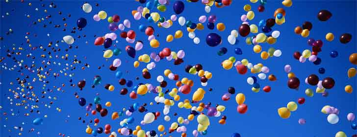 Hundreds of balloons flying off into the sky